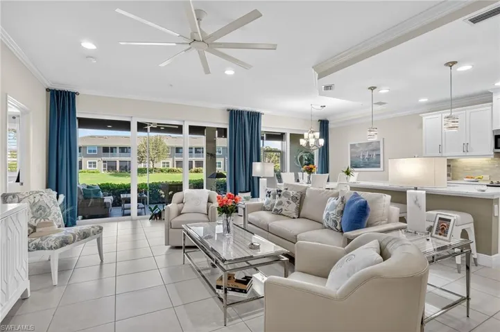 Living room with ornamental molding, a ceiling fan, light tile patterned flooring, a chandelier, and recessed lighting