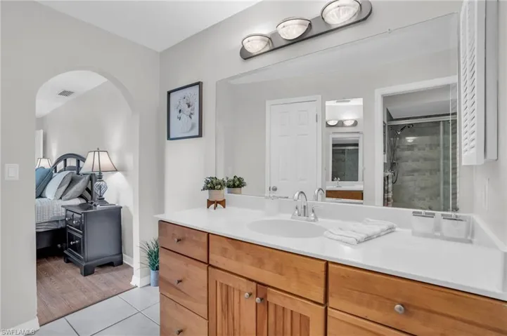 Bathroom featuring vanity, walk in shower, and tile patterned flooring