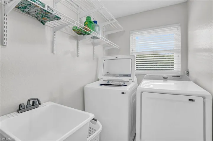 Clothes washing area featuring sink and washing machine and clothes dryer