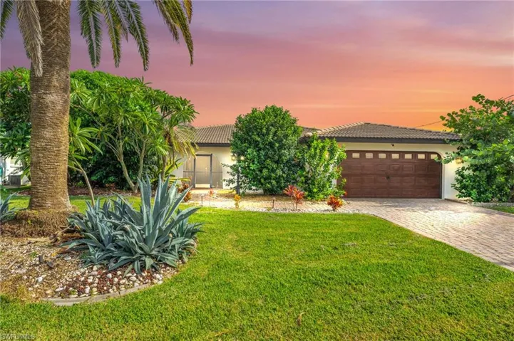 View of front of home with a yard and a garage