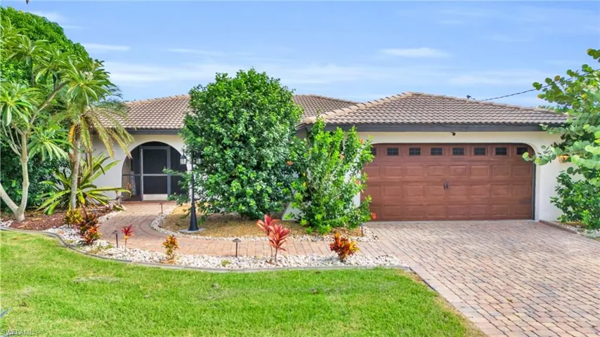 Mediterranean / spanish house featuring a front lawn and a garage