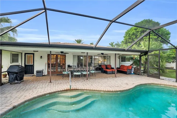 View of swimming pool with a lanai, a patio area, ceiling fan, and an outdoor living space