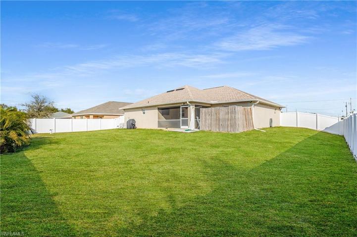 fenced backyard and view of screened patio. View of privacy fence for hot tub
