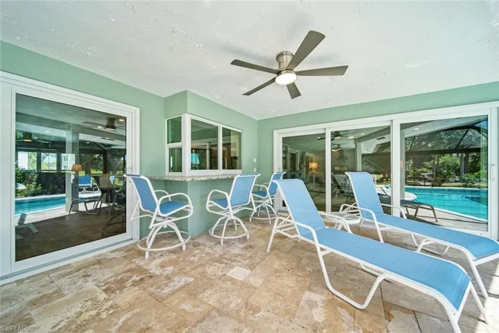 Sunroom / solarium with a ceiling fan, a patio area, and a pool
