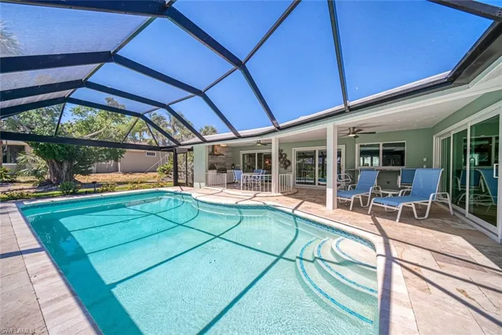 Swimming pool with a patio, a lanai, and a sunroom
