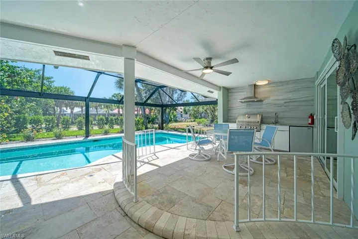 Swimming pool with a patio, a sunroom, a lanai, and a grill