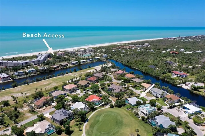 Aerial view of property and surrounding area featuring a large body of water and nearby suburban area