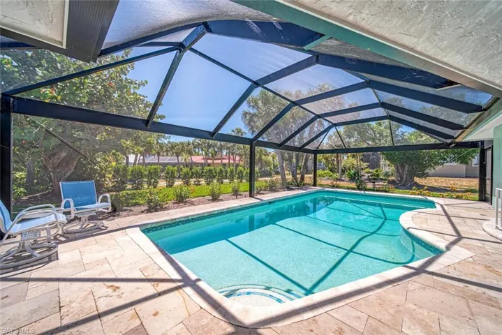 Outdoor pool featuring glass enclosure, a patio, and a sunroom
