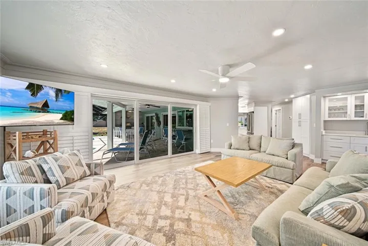 Living room featuring wood finished floors, recessed lighting, ceiling fan, and a textured ceiling