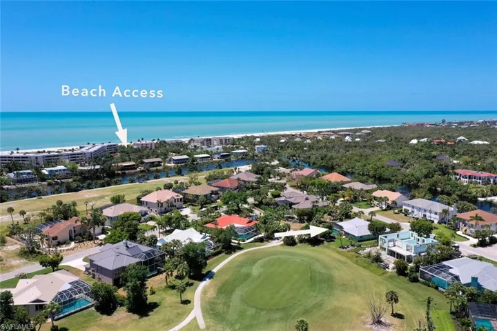 Aerial perspective of suburban area featuring a large body of water and a golf club