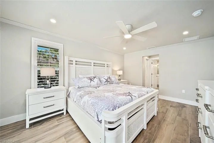 Bedroom with wood tiled floors, ceiling fan, recessed lighting, and crown molding