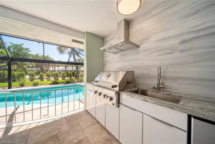 Laundry area with a sink and stone tile floors
