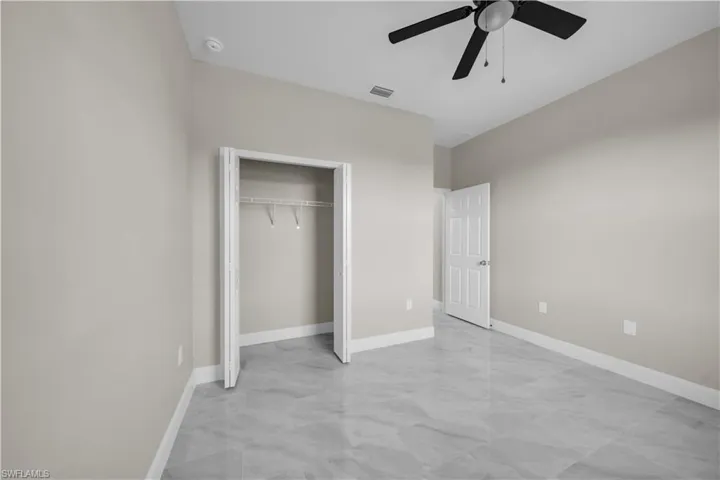 Walk in closet with marble look tile flooring