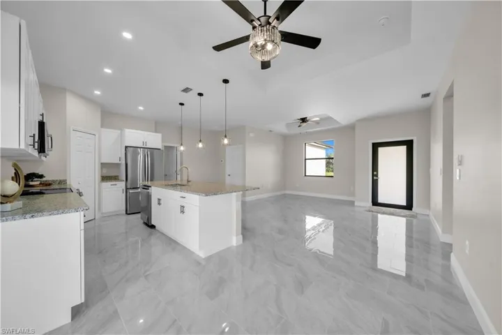 Unfurnished room with light marble finish floors and a ceiling fan
