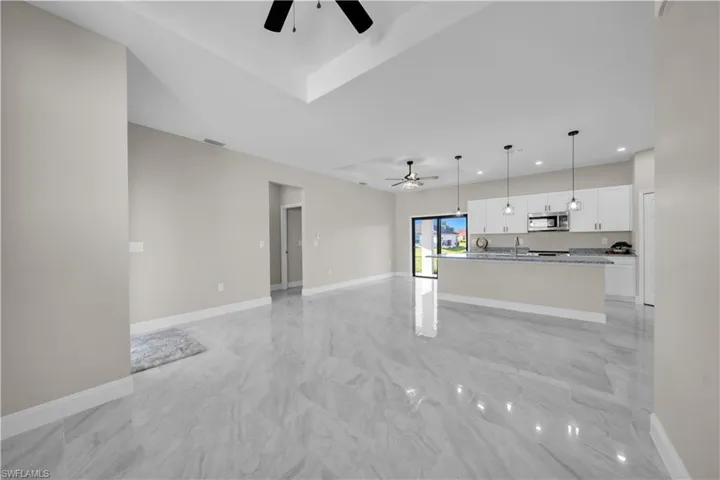Empty room featuring a ceiling fan and baseboards