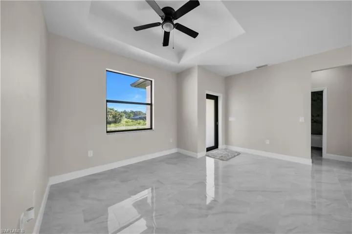 Unfurnished room with light marble finish floors and a ceiling fan