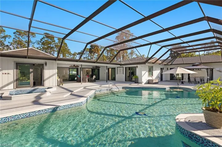 View of swimming pool with a lanai, ceiling fan, and a patio