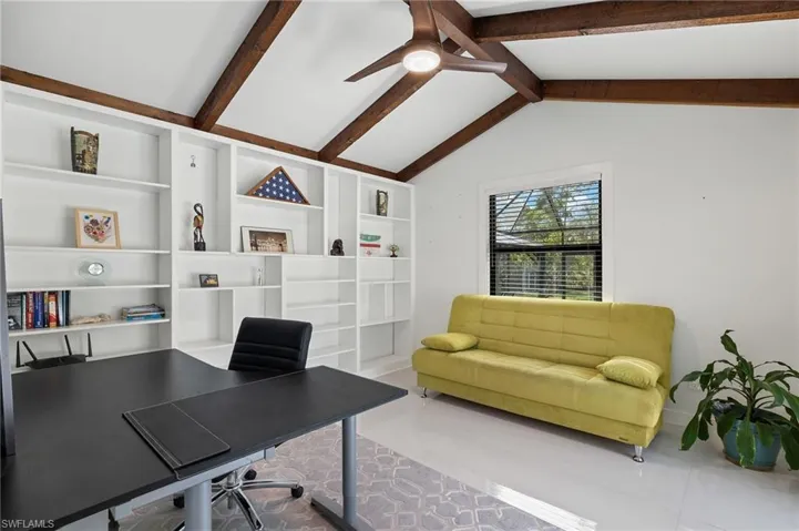 Office space featuring lofted ceiling with beams and built in features