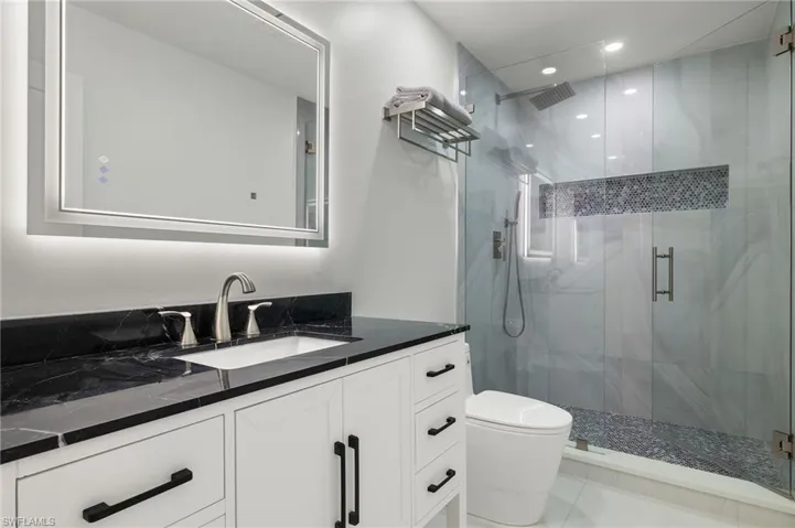 Guest Bathroom 1featuring tile patterned floors, vanity, toilet, and a shower with door