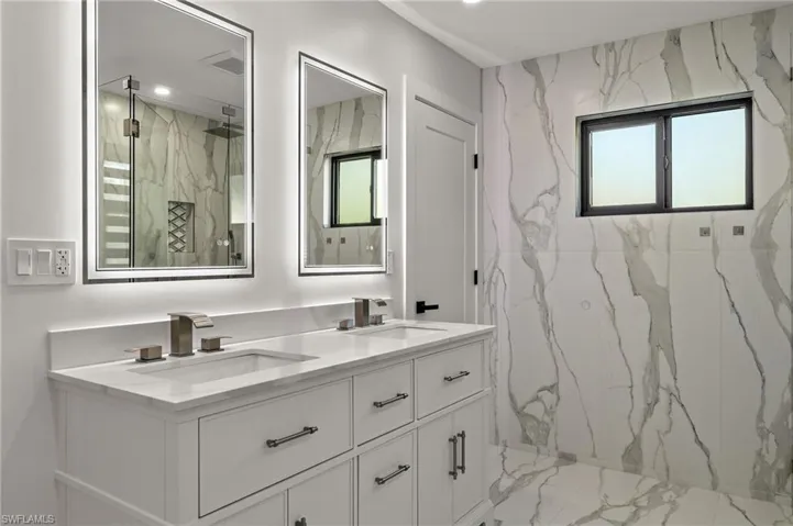 Owner's Bathroom with vanity, tiled shower, and a wealth of natural light