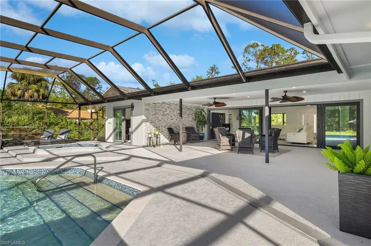 View of patio featuring glass enclosure and ceiling fan