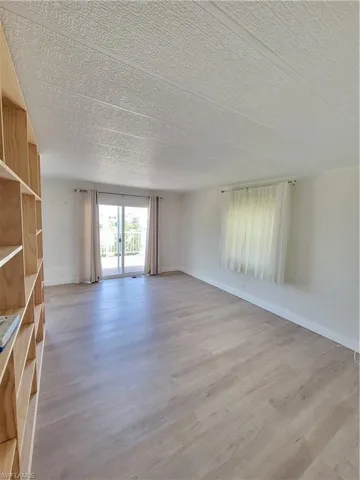 Empty room with light wood-style flooring and a textured ceiling