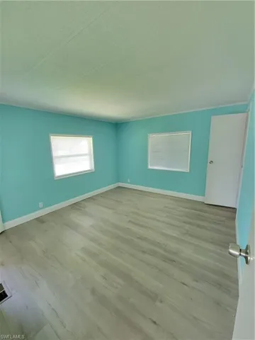 Unfurnished room featuring wood finished floors and baseboards
