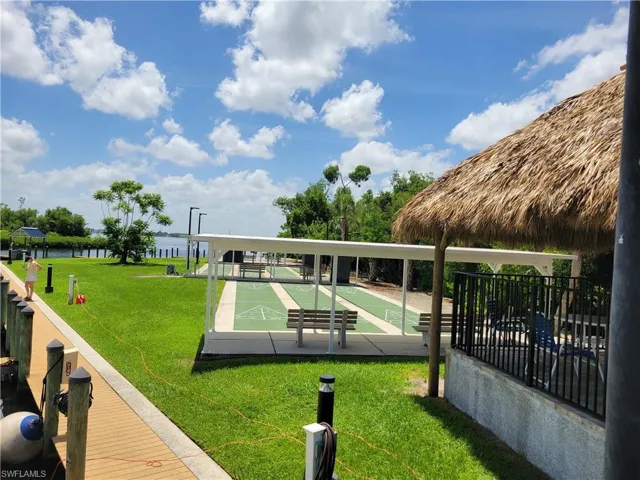 Surrounding community featuring a lawn and shuffleboard