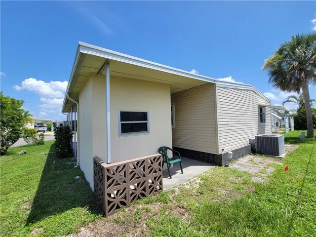 View of side of home featuring a yard and a patio