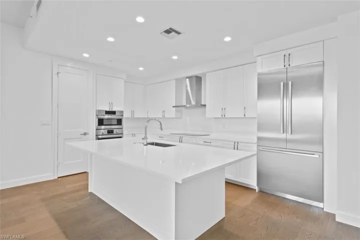 Kitchen with stainless steel appliances, white cabinetry, recessed lighting, and light wood finished floors