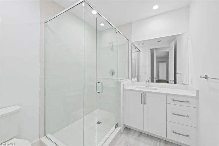Bathroom featuring a shower stall, vanity, and recessed lighting