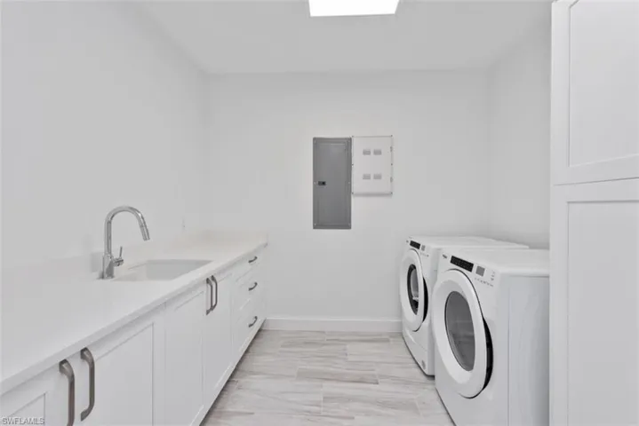 Laundry area featuring cabinet space, electric panel, and washing machine and dryer