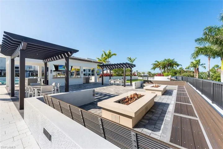 View of property's community featuring a pergola, a fire pit, outdoor dining area, and a patio area