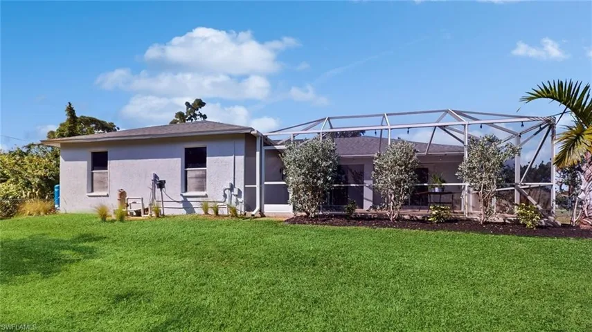 Rear view of house with screened enclosure