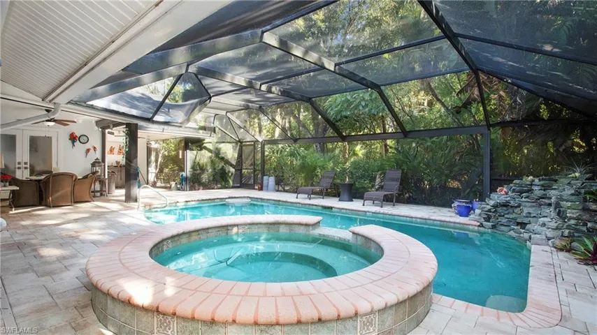 View of pool with a patio area, a pool with connected hot tub, a lanai, and french doors