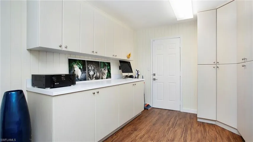 Bonus room - which can be an in-law setup with light countertops, dark wood-type flooring, and white cabinets