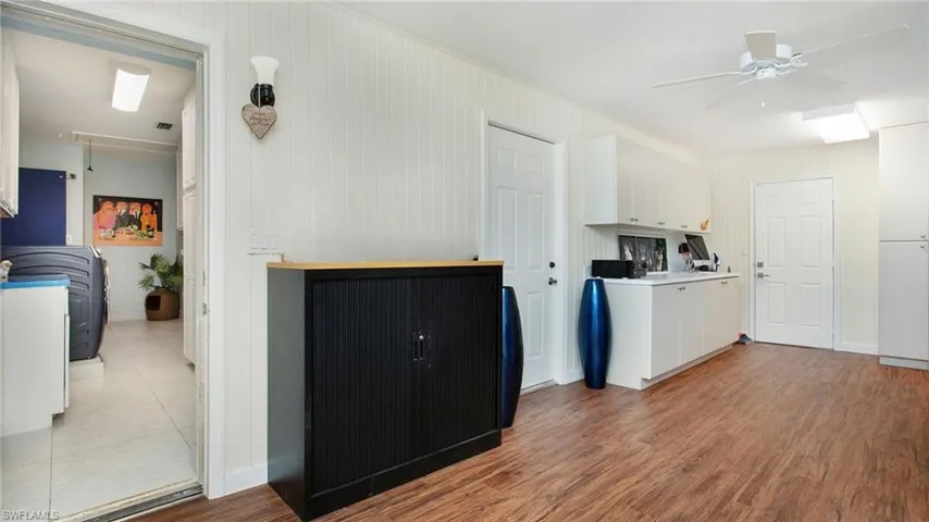 Bonus room with white cabinets, ceiling fan, light wood-style flooring, and light countertops