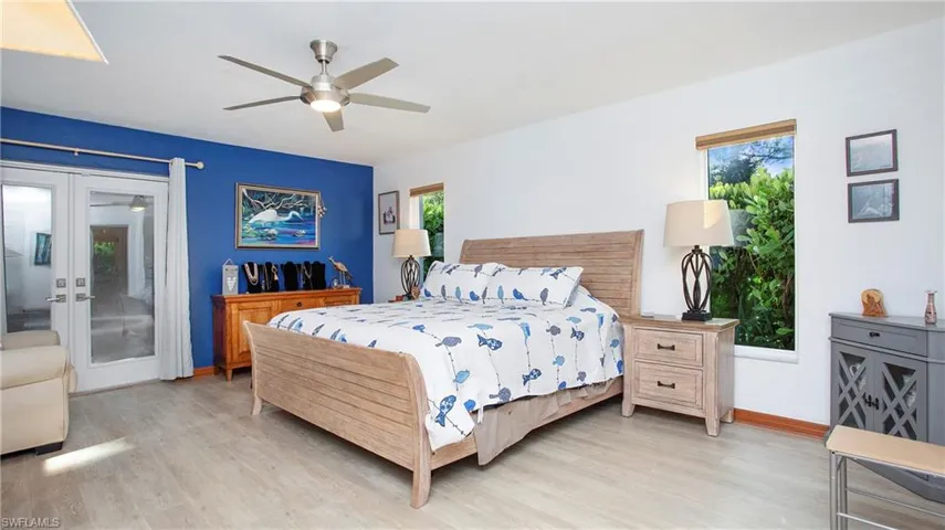 Bedroom featuring access to outside, french doors, light wood-style flooring, and ceiling fan