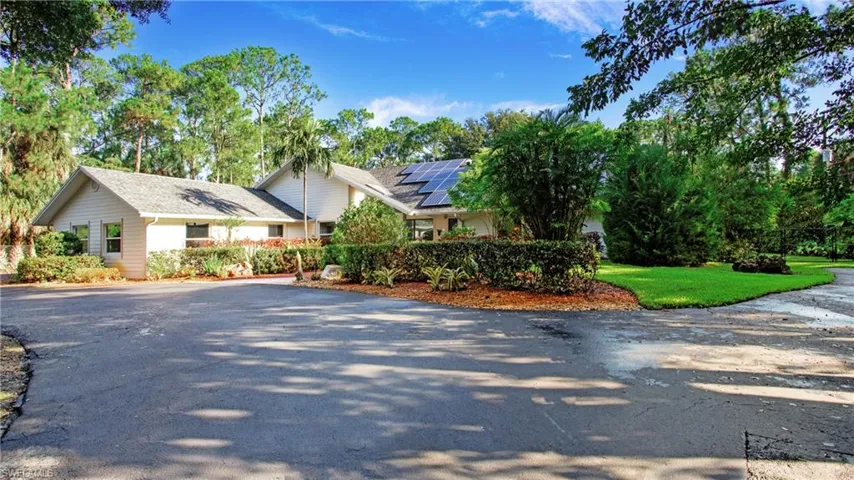 View of front of home featuring driveway and solar panels
