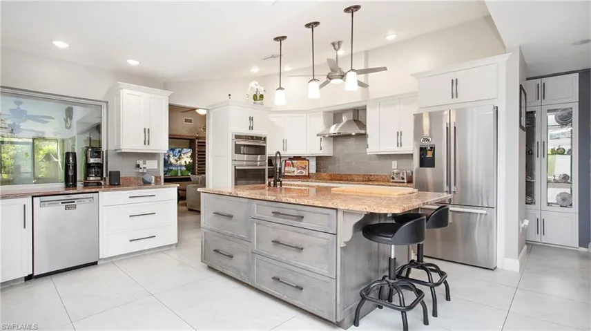Kitchen with stainless steel appliances, a ceiling fan, decorative backsplash, and recessed lighting