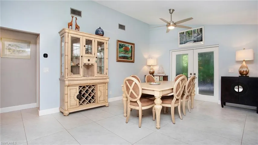 Dining space featuring a ceiling fan, french doors, light tile patterned floors, and high vaulted ceiling