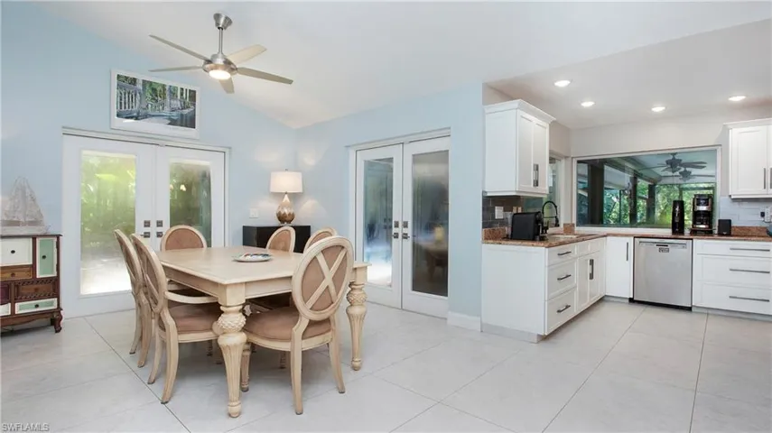 Dining room with french doors, a ceiling fan, lofted ceiling, recessed lighting, and light tile patterned floors