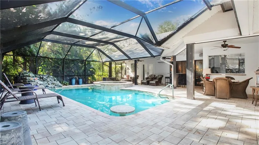 View of pool with a ceiling fan, a patio, a pool with connected hot tub, and outdoor dining space