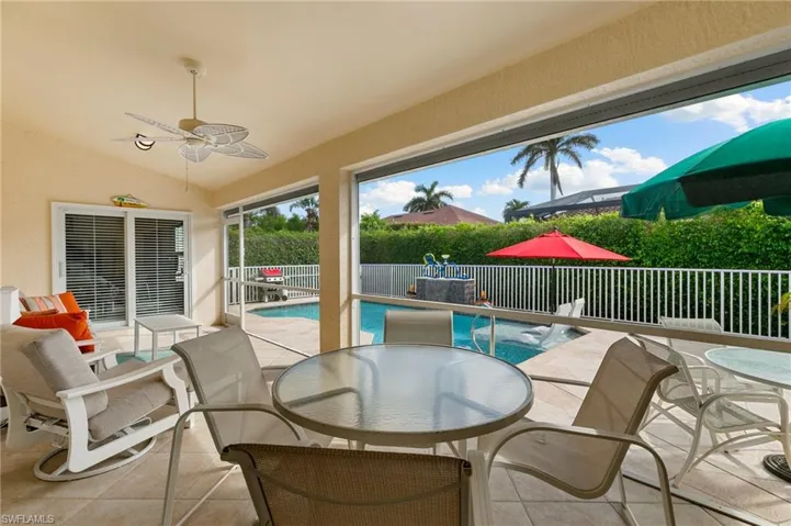 View of screened lanai featuring a fenced in salt water pool and ceiling fan