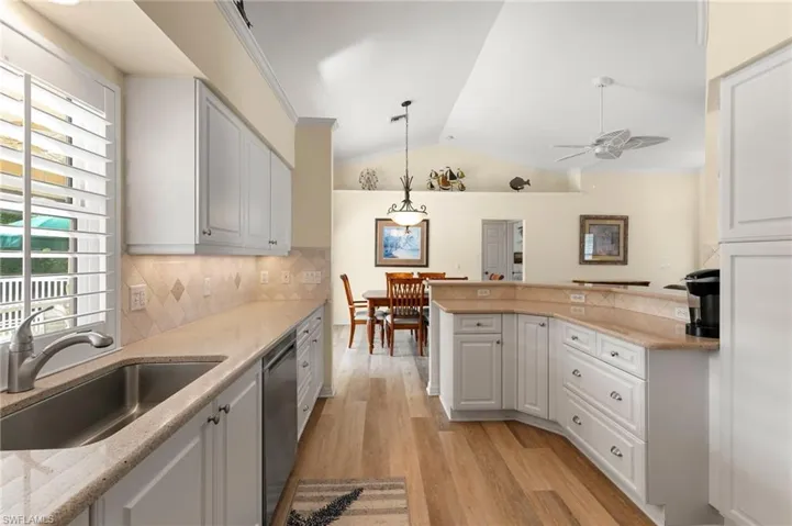 Kitchen featuring white cabinetry, stainless steel sink and appliances