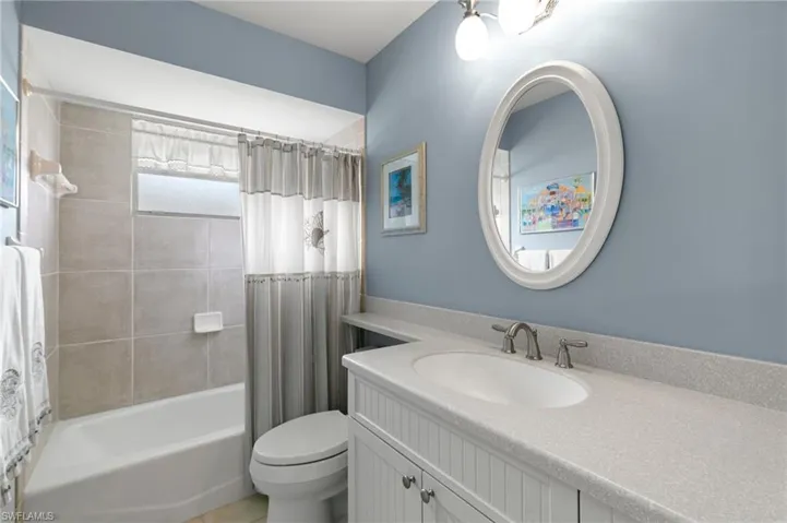 Second bathroom featuring vanity, toilet, and shower / bath combo with shower curtain