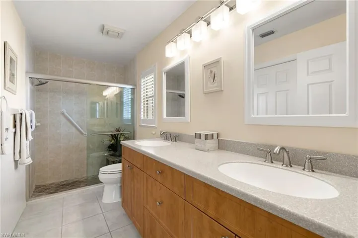 Master Bathroom featuring tile patterned flooring, vanity, toilet, and an enclosed shower