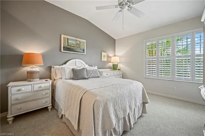 Bedroom with carpet flooring, ceiling fan, and vaulted ceiling