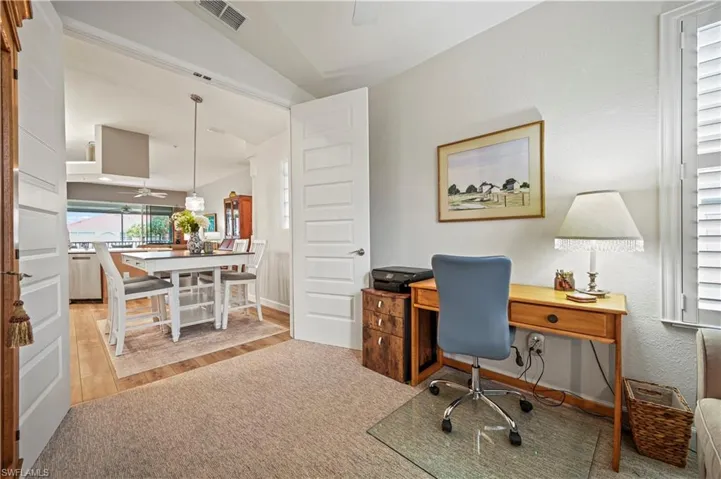 Office space with ceiling fan, vaulted ceiling, and light hardwood / wood-style floors
