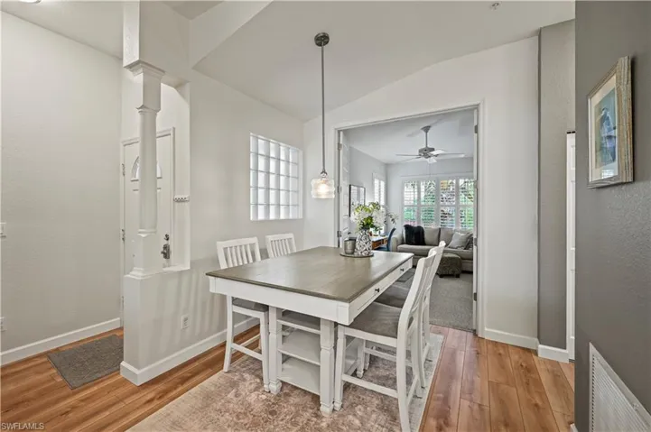 Dining room with ceiling fan, light wood-type flooring, and lofted ceiling